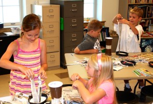 St. Helen School fifth-grader Rosie Murray, second-grader Olivia Lewis and third-graders Gregory Bores and Jack Murray have fun making paper mache drums during summer art camp.