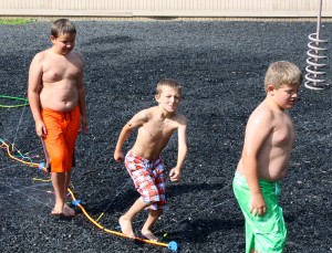 Submitted From left, St. Helen School fourth-graders John Cooper and John Paul Nowak and third-grader Gregory Bores take a break from fitness camp to cool off running through the sprinklers.
