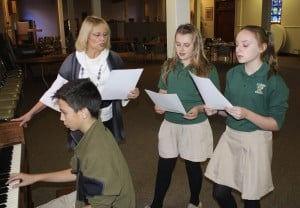 Submitted St. Helen School seventh-graders Garrett Sah, Makayla Hart and Allie Martin practice the music for Friday’s Mass with music teacher Annemarie Wenner.