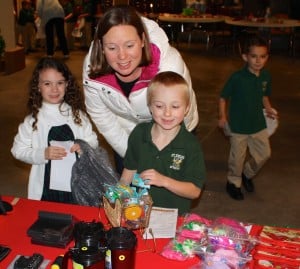 Submitted Kindergartners Mykaela Cox, Tyler Buck and Aaron DeMille Christmas shop with Mrs. Melissa Joyce at Santa’s Shop at St. Helen School.