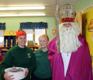 Submitted Eighth-grade elves Hannah Taylor and Maggie Murray assist St. Nick during his visit to St. Helen School. He told the students to be nice to their siblings and that Christmas is a time for giving.