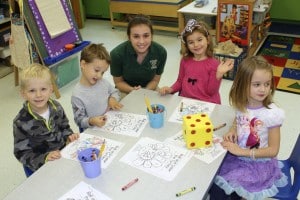 Submitted St. Helen School eighth-grader Lilly Garcia helps preschoolers Hunter Lynce, Chase Wolfram, Ella Strmen and Ellie Welhouse with their coloring.