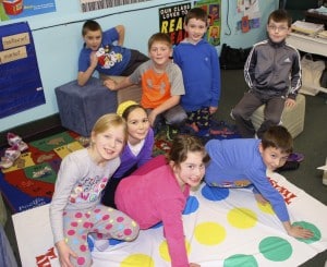 St. Helen second-graders (l to r) front row: Anna Russell, Julia Suvak, Seianna Coon, Mario Romagni; and back row: Paul Brent, Jason Brent, Luke Nedved and Jack Slattery play a game of Twister on “Cozy Day” during Catholic Schools Week.