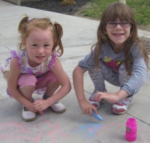 Submitted St. Helen preschoolers Anna Risk and Missy Allen create sidewalk art with chalk on their last day of school before summer vacation.