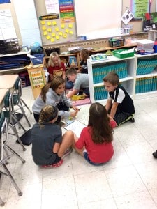 Submitted Chardon High School students who are currently taking a child development class help Maple second-graders work on their math skills.