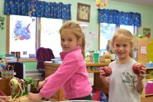 Submitted With Mrs. Mead’s help, kindergartners Giuliana Adair, left, and Alexis Milnark use an old-fashioned apple peeler as part of the process of making applesauce.