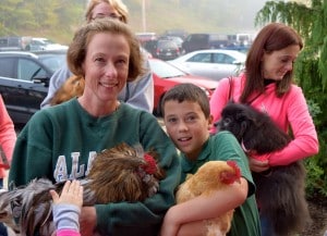 Submitted Mrs. Fisher brings her rooster Clause and third-grader Simon Fisher, of Huntsburg, brings Houdina the chicken for a blessing by Fr. McPhillips.