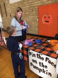 Submitted Chagrin Falls High School student Riley Kirkpatrick assists a boy at the Pin the Face on the Pumpkin booth.