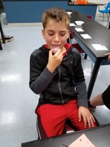 Submitted Cardinal sixth-grader Tim M. uses the taste test to determine the identity of the mineral he’s holding.