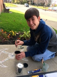 Submitted Chardon eighth-grader Nate Vilardo paints a welcome spot at the front door entrance for people to stand on when waiting to be buzzed into the school. He is part of a group of CMS art students using their talents to brighten up Chardon Middle School.