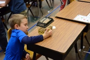 Submitted First-grader Kody L. studies an aquarium to determine if the contents are considered to be living or non-living. The experiment was part of a recent science lab held in class.