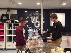 Submitted West Geauga High School student Jesse Todd purchases an item at the Café Achieve store. Entrepreneurship student Cole Khas is working the register.