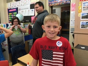 Submitted Third-grader Landon G. proudly shows his “I voted” sticker after casting his electronic vote for the charity he wanted Dr. Seuss to support.