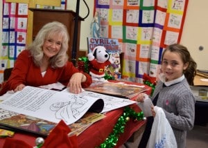 Submitted First-grader Aurelia Chiacchiari buys a coloring book for her sister from Ms. Joan Nemeth at the St. Helen School Santa Shop.